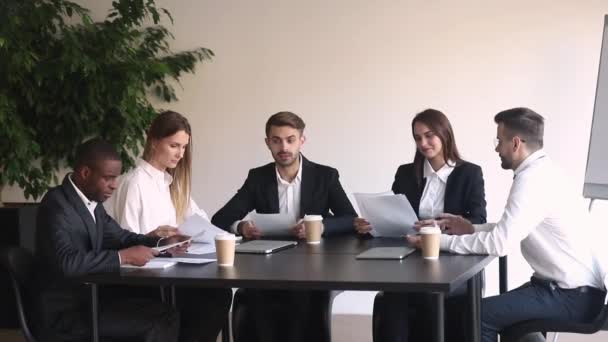 Compañeros de negocios multirraciales negociando sentados en la mesa en la sala de juntas — Vídeos de Stock