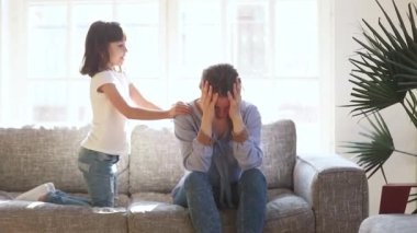 Hiperaktif kız, koltukta oturan yorgun anneyi çekiştiriyor.