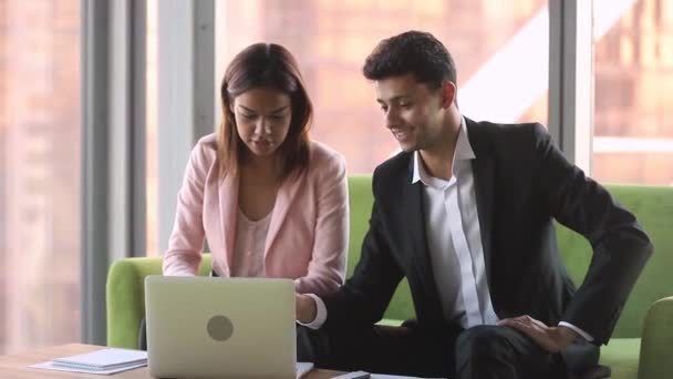Diverse collega 's met laptop zittend op de bank bespreken zakelijke kwesties — Stockvideo