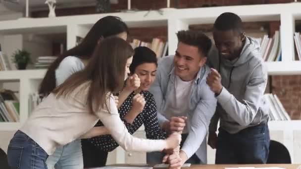 Heureux étudiants universitaires multiethniques unis empilant des poings engagés dans le team building — Video