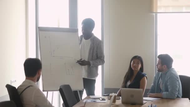 Treinador preto masculino dar flip chart apresentação para funcionários multiétnicos — Vídeo de Stock