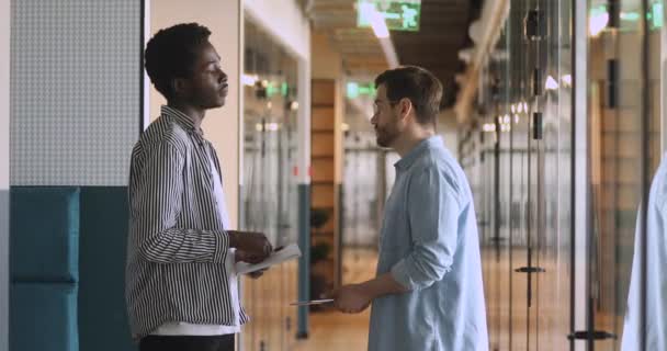 Diversos socios masculinos hablando apretón de manos de pie en el pasillo de la oficina — Vídeos de Stock