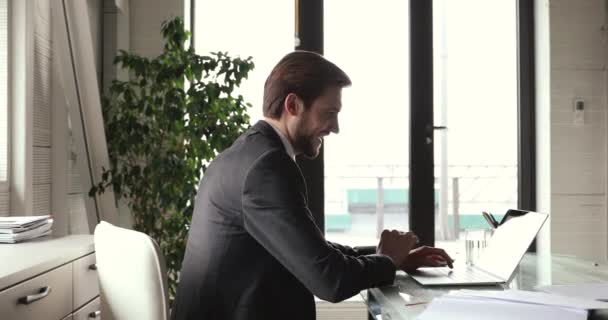 Glücklicher Geschäftsmann zufrieden beendet Arbeit in der Pause entspannt am Arbeitsplatz — Stockvideo