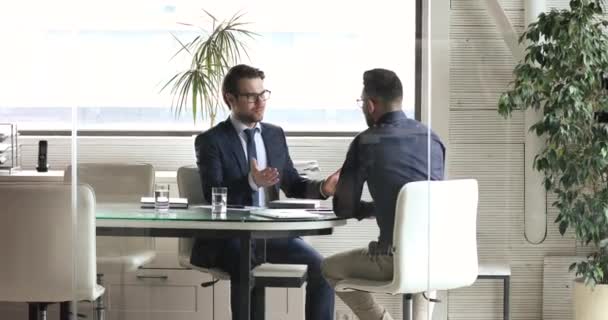 Zwei männliche Exekutivpartner geben sich nach Verhandlungen hinter Glas die Hand — Stockvideo