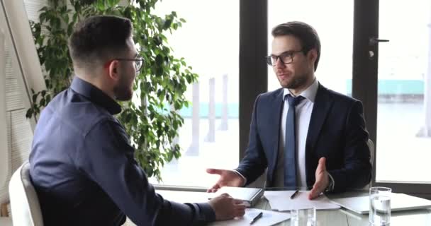 Уверенный кавказский бизнесмен пожимает руку арабскому партнеру на встрече — стоковое видео