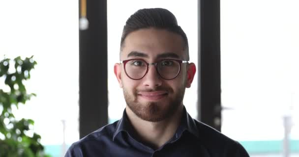 Hombre de negocios árabe sonriente confiado con gafas mirando a la cámara — Vídeo de stock