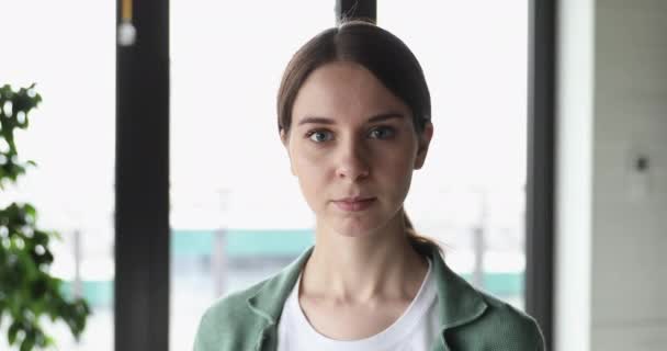 Zelfverzekerde glimlachende jonge vrouwelijke professionele poseren in kantoor, close-up portret — Stockvideo
