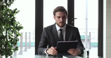 Takım elbiseli genç işadamı uzaktan kumandalı web kamerası iş görüşmesi yapıyor.