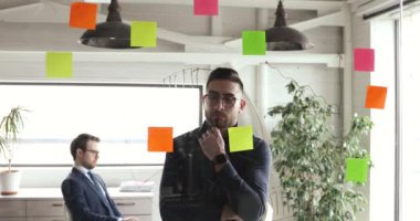 Arap işadamı yapışkan notlara bakarak projenin ilerlemesini düşünüyor