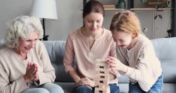 Šťastná babička a maminka podporující malé dítě v stavět hru. — Stock video