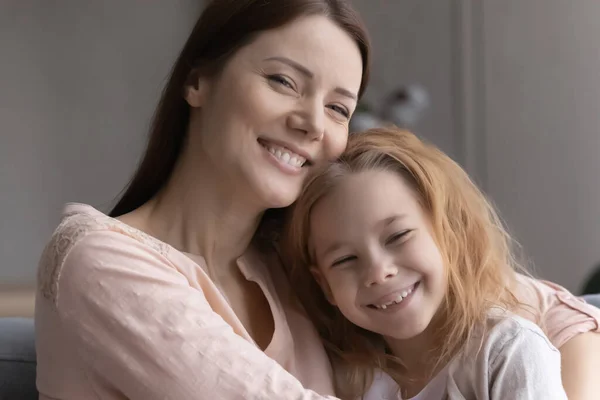 Porträtt av leende ung mamma och liten dotter kramas — Stockfoto