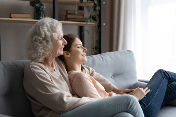 Bonne maman mature et fille adulte se détendre sur le canapé rêvant — Photo