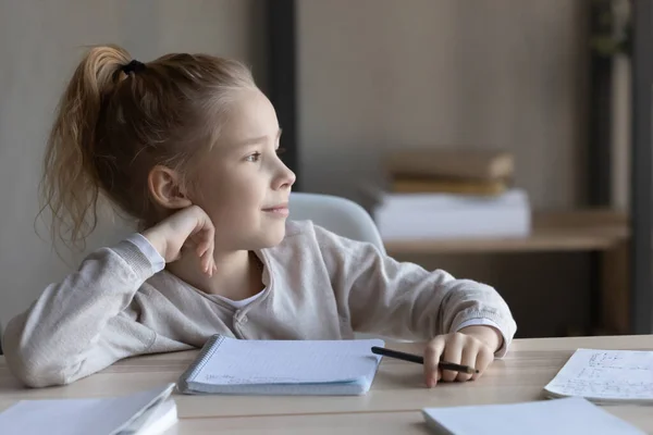 Dromerig klein meisje afgeleid van het studeren thuis — Stockfoto