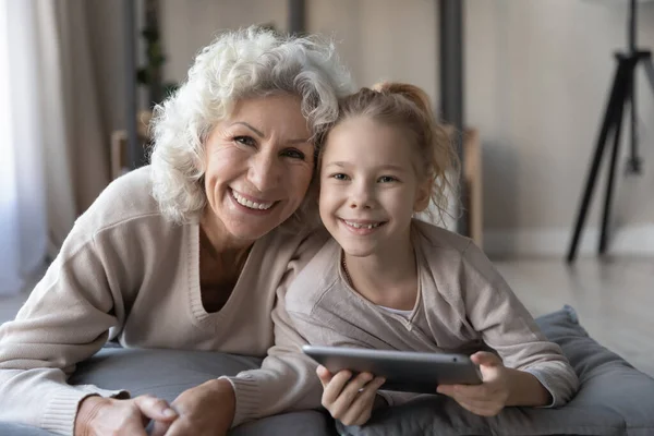 Портрет счастливой бабушки и внучки с помощью планшета — стоковое фото