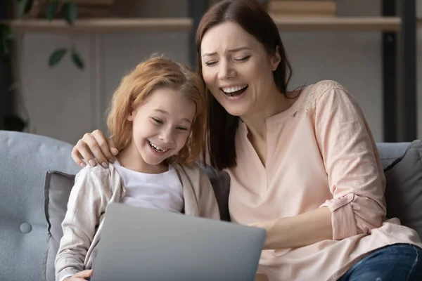 Alegre mamá y su hija pequeña usando el ordenador portátil juntos — Foto de Stock