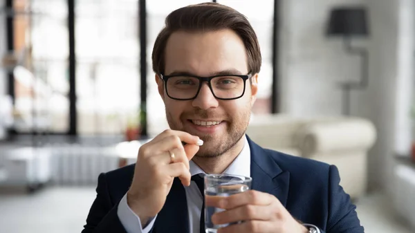 Portrait of smiling male worker take medicines at workplace — Stock Photo, Image