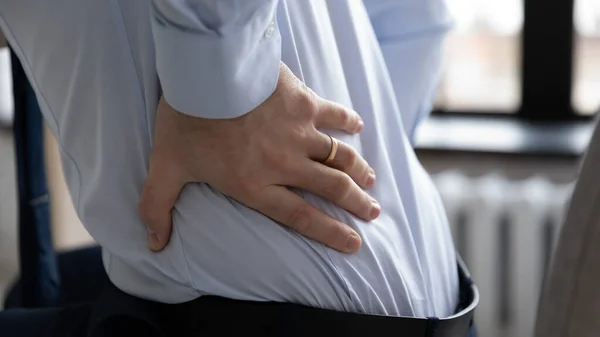 Close-up van mannelijke werknemer lijden aan rugpijn — Stockfoto