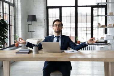 Sakin işadamı ofisinde yoga yapıyor.