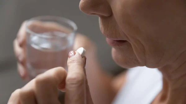 Primo piano della donna anziana con pillola — Foto Stock