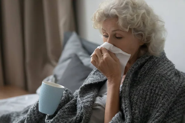 Niedobrze senor kobieta cierpi na grypę w domu łóżko — Zdjęcie stockowe