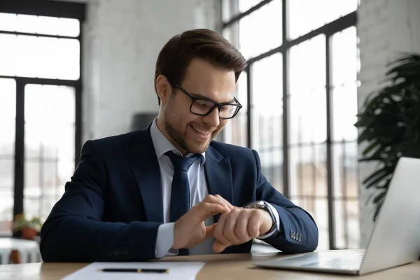 Souriant mâle employeur vérifier montre à main sur le lieu de travail — Photo