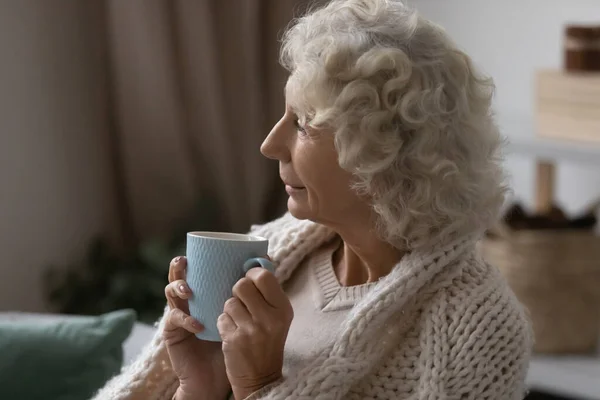 高齢者50代女性リラックス上のソファお茶 — ストック写真
