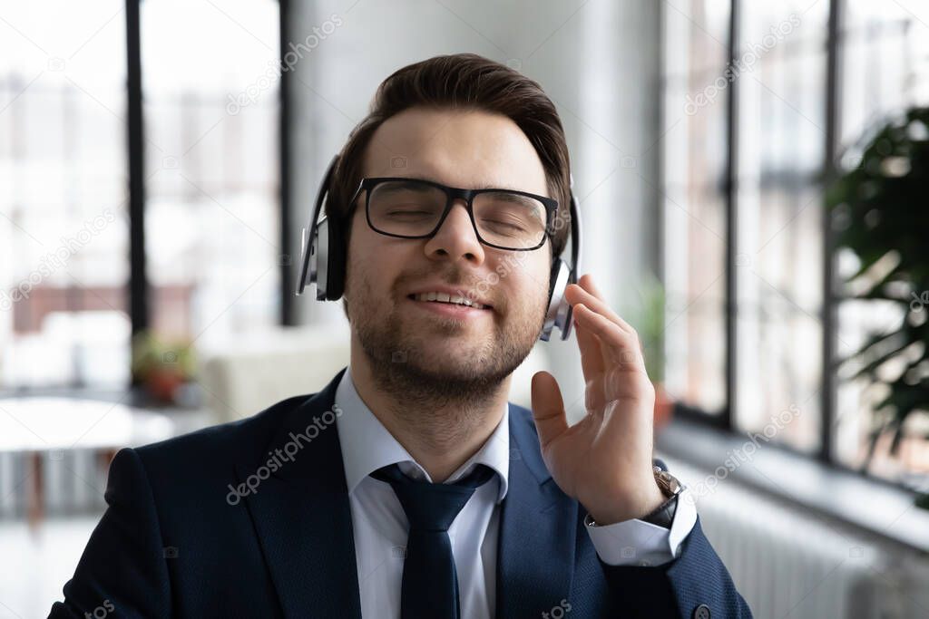 Happy businessman enjoy music play in headphones