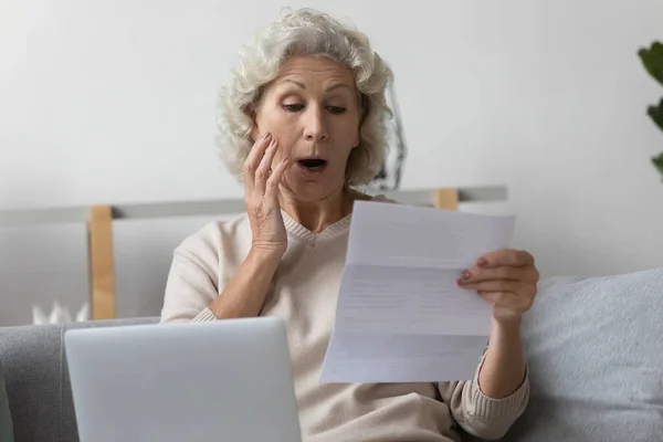 Geschockte reife Frau frustriert über unerwartete Nachricht in Briefkorrespondenz — Stockfoto