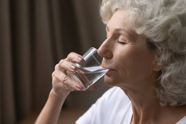 Tørst, moden kvinne som har glass vann. – stockfoto