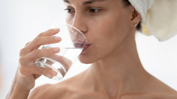 Закройте красивую женщину, пьющую чистую минеральную воду
