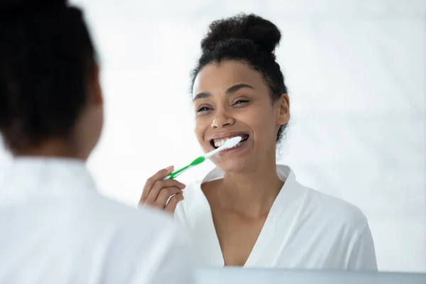 Lustro odbicie uśmiechnięty Afroamerykanin młoda kobieta mycie zębów — Zdjęcie stockowe