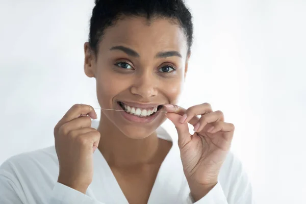 Head shot portrait smiling African American woman using dental floss — Stock Photo, Image