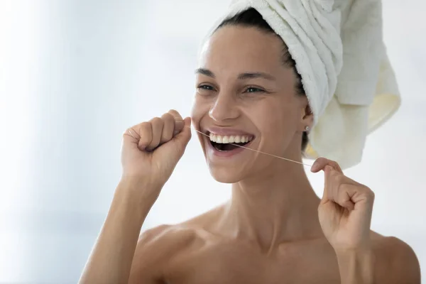 Head shot smiling beautiful woman holding dental floss, cleaning teeth — Stock Photo, Image