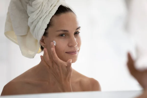 Close-up spiegel reflectie vrouw toepassing moisturizer gezicht crème — Stockfoto