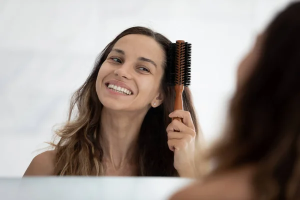 頭ショット笑顔女性ブラッシング長い髪でバスルーム — ストック写真