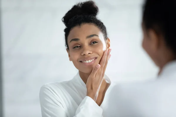 Zdjęcie głowy uśmiechnięta Afroamerykanka dotykająca gładkiej skóry twarzy — Zdjęcie stockowe