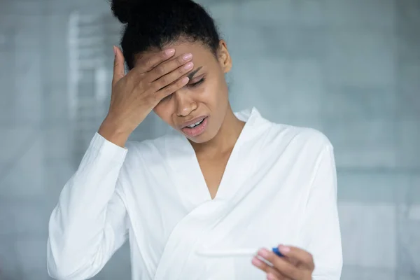 Primer plano infeliz estresado mujer afroamericana sosteniendo prueba de embarazo — Foto de Stock