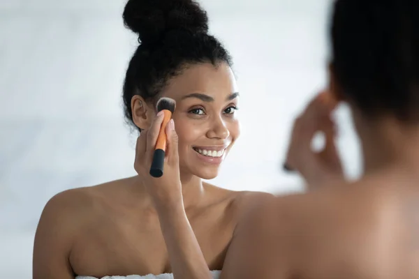 Testa colpo sorridente donna afroamericana utilizzando pennello cosmetici — Foto Stock