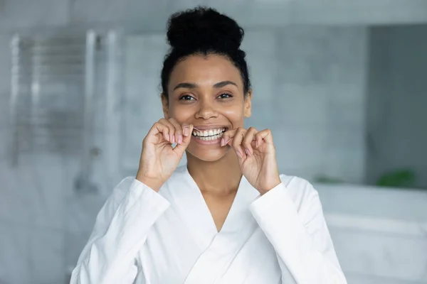 Hlava záběr portrét usmívající se Afroameričanka pomocí zubní nitě — Stock fotografie