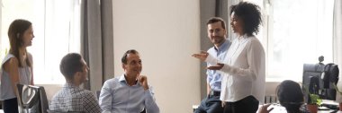 Afrikalı takım lideri ofis toplantısında iş arkadaşlarıyla konuşuyor