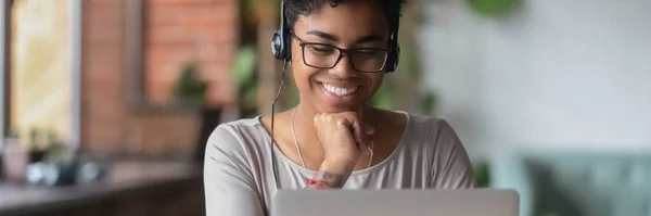 Sonriente chica africana usar auriculares ver webinar en línea utilizar el ordenador portátil — Foto de Stock