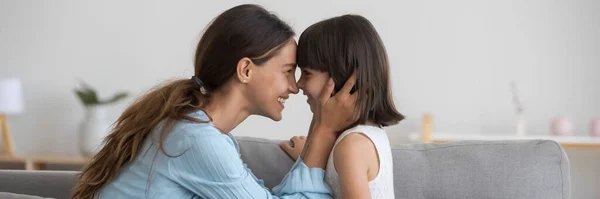 Любящая мать трогает носы с очаровательной маленькой дочерью вид сбоку — стоковое фото