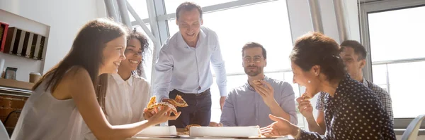Diverse colleagues gathered together eating pizza laughing enjoy communication — Stock Photo, Image
