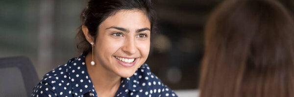 Indian girl having pleasant conversation with colleague during break