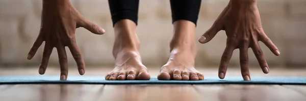 Woman practising yoga forward bend or uttanasana position closeup image — Stock Photo, Image