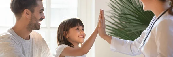 Klein meisje geeft high five naar vrouwelijke kinderarts tijdens bezoek — Stockfoto
