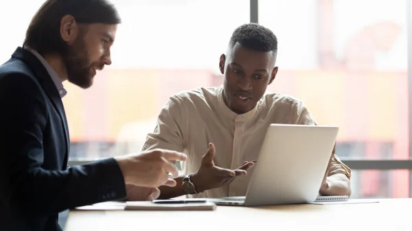 Multi-ethnic businessmen looking at laptop screen discussing new application — Stock Photo, Image