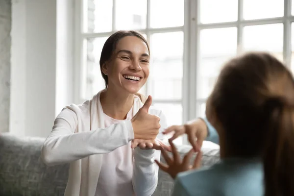 Mulher branca sorridente aprende língua gestual com criança — Fotografia de Stock
