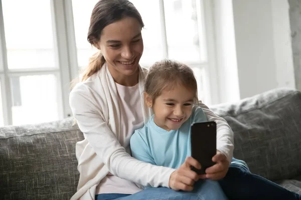 Mamma felice e piccola figlia usano il cellulare insieme — Foto Stock