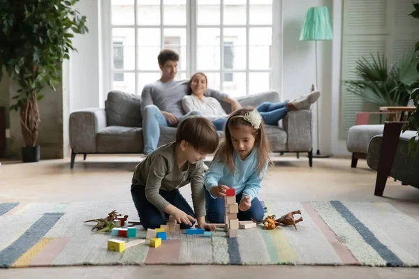 Kleine Kinder spielen zu Hause mit Bauklötzen — Stockfoto